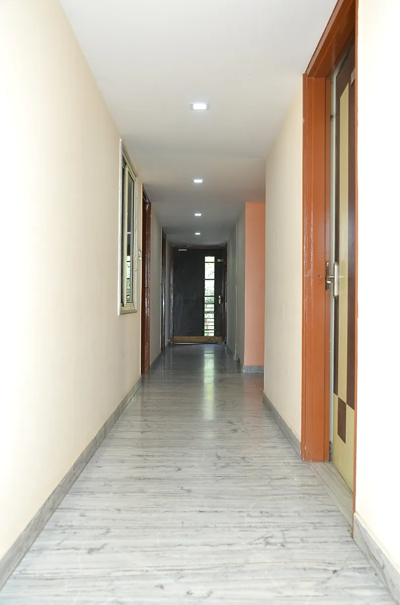 Clean marble-floored corridor connecting the hostel rooms